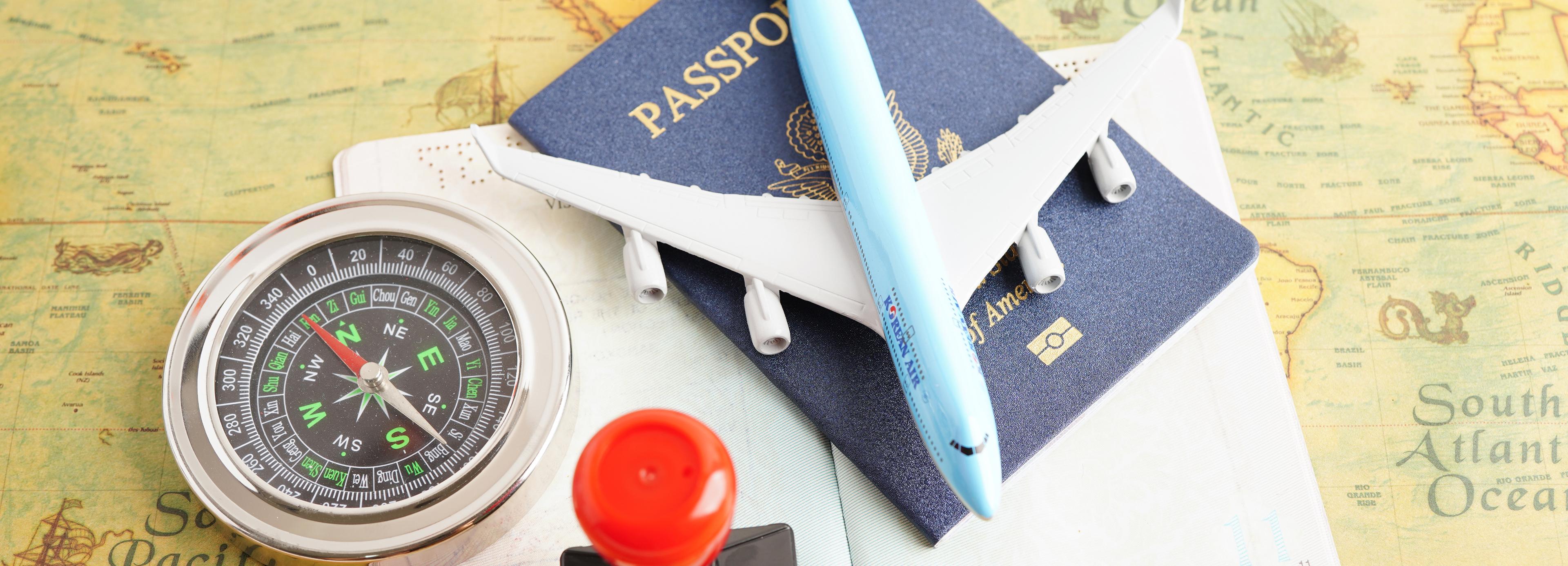 A passport alongside a compass, illustrating the essentials for travel and navigation.